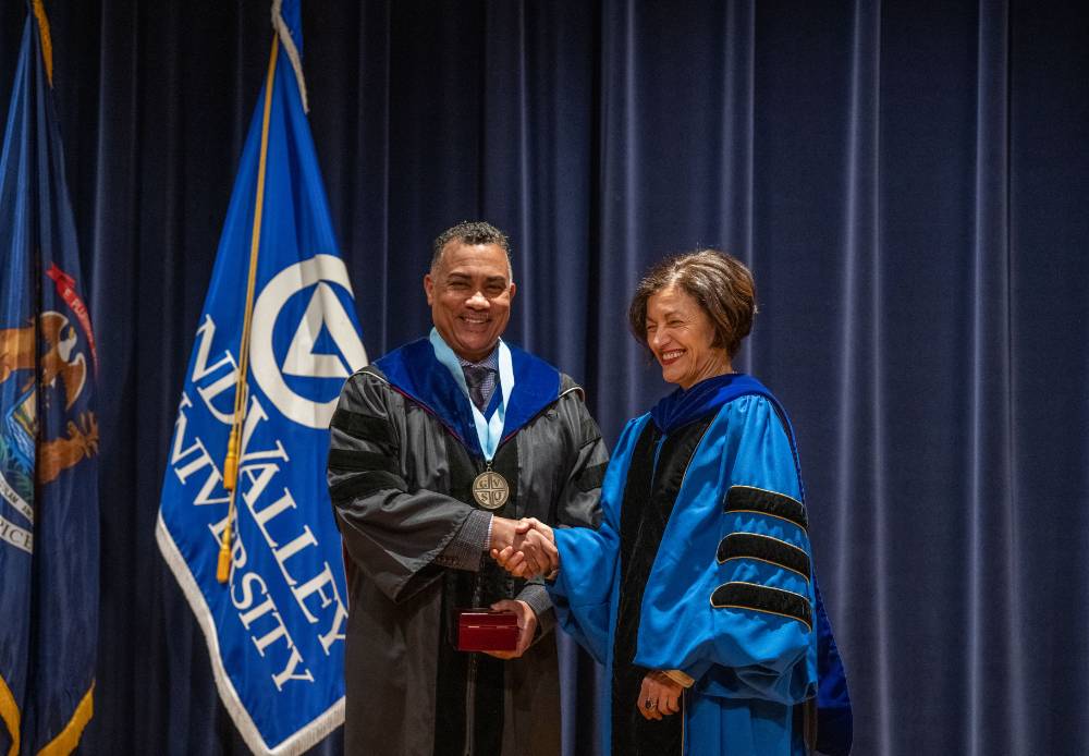 Provost Mili shakes hands with man